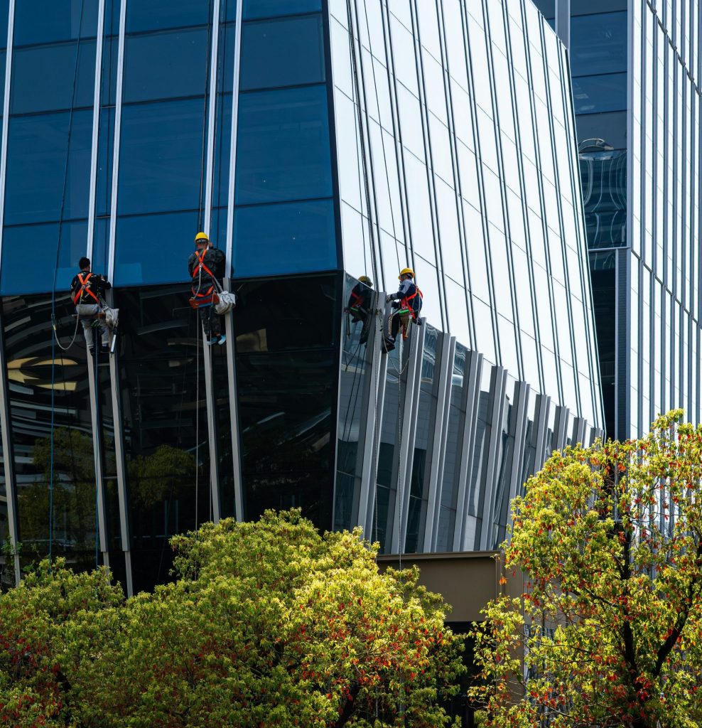 Workers cleaning windows on a modern glass building
